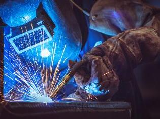 A person welding in full protective gear.